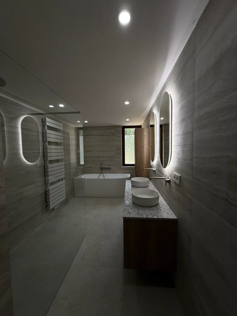 Perspective de la salle de bain rénovée : à gauche la douche et le radiateur sèche-serviettes, au fond la