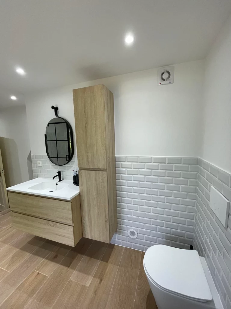 Meuble de salle de bain suspendu en bois et finitions modernes dans une rénovation à Saint-Vith