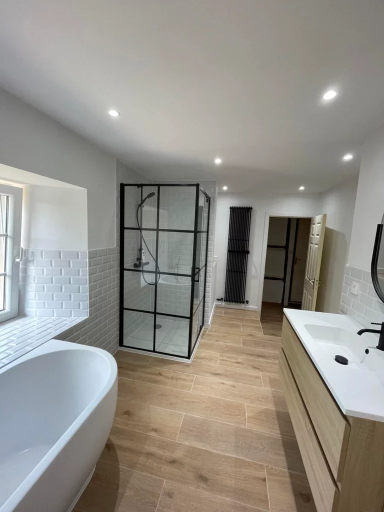 Vue d’ensemble avec meuble double vasque, douche vitrée et baignoire îlot à Saint-Vith