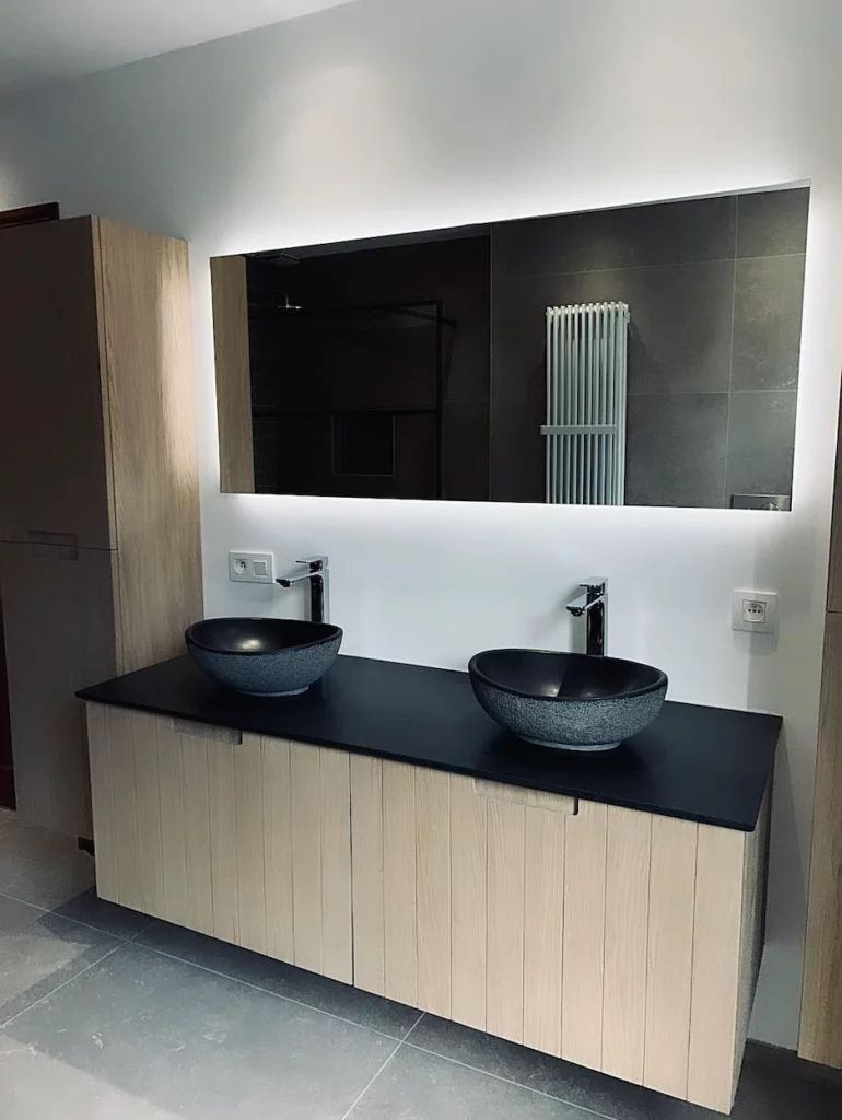 Meuble double vasque en bois avec vasques à poser et miroir rétroéclairé dans une salle de bain contemporaine