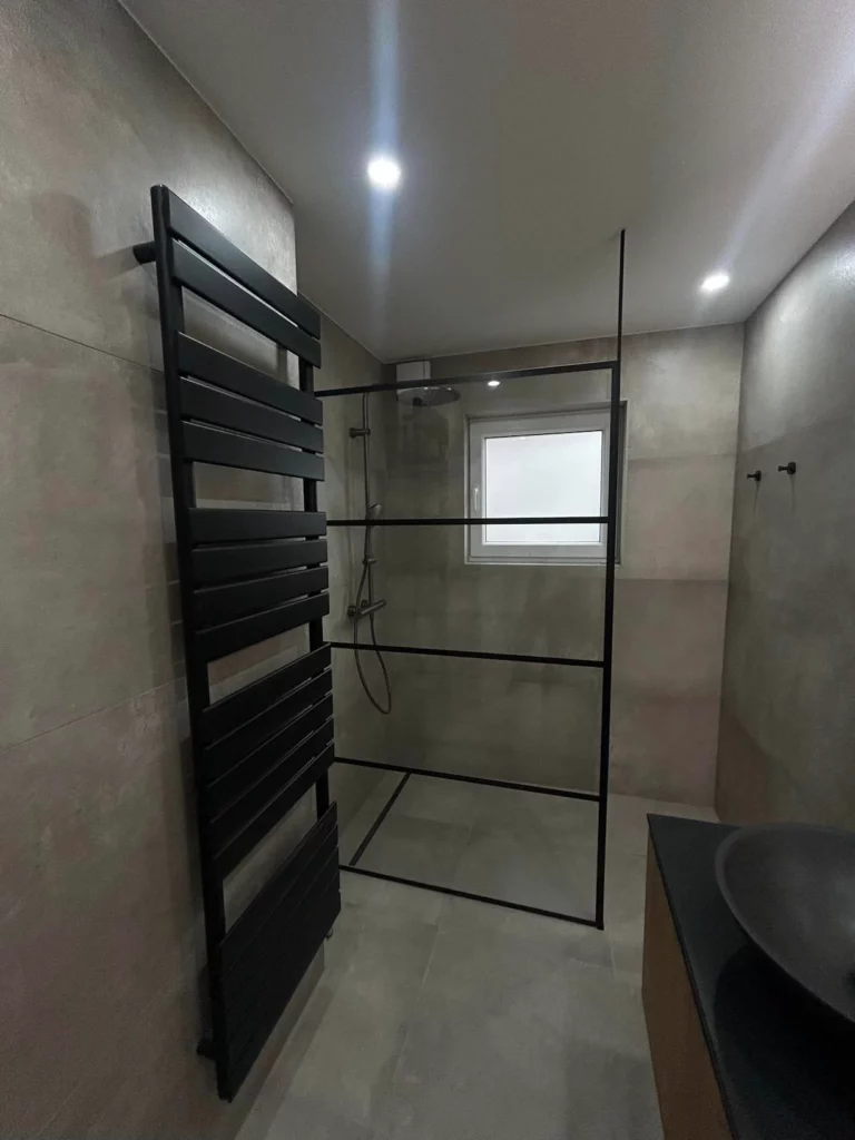 Salle de bain contemporaine rénovée à Welkenraedt avec douche vitrée style atelier et finitions modernes
